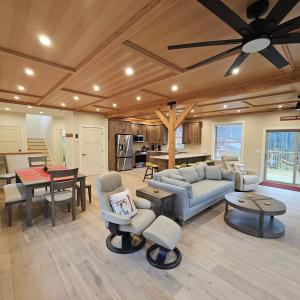 Powder Run - Modern 3BR Basecamp with Hot Tub, AC, EV Charger & Flat Parking في North Sherburne: غرفة معيشة كبيرة مع مروحة سقف ومطبخ