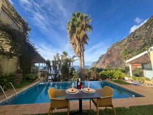 滨海雅尔丁Bela Vigia的游泳池旁边的一张桌子和几把椅子