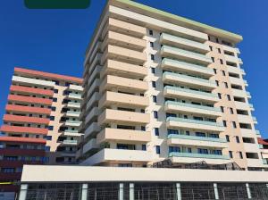a tall apartment building in front of a blue sky at Modern Studio With Balcony - Unirea Towers Iasi in Iaşi