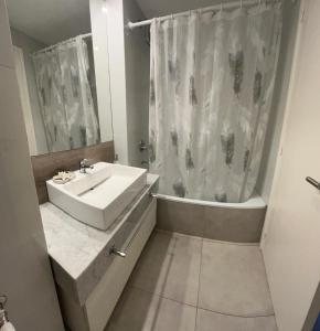 a bathroom with a sink and a tub and a shower at Carpe Diem Monte Hermoso in Monte Hermoso