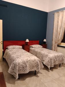 a bedroom with two beds and a blue wall at traivicolidifoligno in Foligno