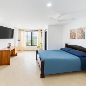 Cerete con Estilo في Cereté: غرفة نوم بسرير ازرق وتلفزيون بشاشة مسطحة