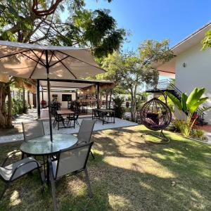 a patio with tables and chairs and an umbrella at Abode Boutique Resort - Hua Hin in Hua Hin