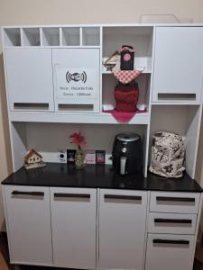a white cabinet with a black counter top at Recanto feliz in São Thomé das Letras