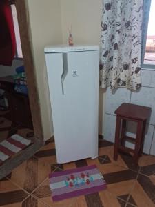 a white refrigerator on the floor in a room at Recanto feliz in São Thomé das Letras