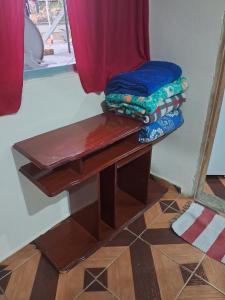 a wooden table with a bench next to a window at Recanto feliz in São Thomé das Letras