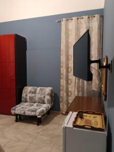 a living room with a chair and a tv at traivicolidifoligno in Foligno