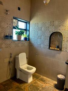 a bathroom with a toilet and a window at Chique Shanti Villa in Mandrem +11 photos