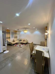 un soggiorno con tavolo, sedie e divano di Studio Meublé Bonamoussadi 4è a Bonamoussadi