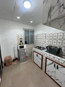 una cucina con lavello e fornello forno superiore di Studio Meublé Bonamoussadi 4è a Bonamoussadi