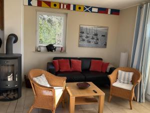a living room with a black couch and chairs at Haus TimpeTe am Breetzer Bodden in Vieregge +21 photos