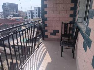 a balcony with a chair and a view of a city at Studio Meublé Bonamoussadi 4è in Bonamoussadi +2 photos