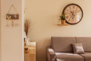 a living room with a couch and a clock on the wall at IL DANDY appartamento con parcheggio in Trieste