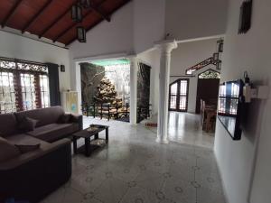 a living room with a couch and a christmas tree at Green Relax Villa in Mirissa