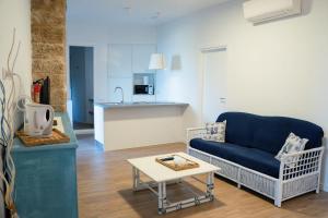 a living room with a blue couch and a table at La Terrazza sui Bastioni in Alghero