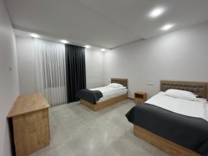 a room with two beds and a table in it at Harutyunyants Hall in Ijevan