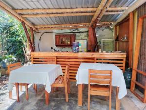 two tables and chairs in a kitchen with a counter at Homestay Natural Paradise habitación 1 in San Cristóbal