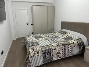 a bedroom with a bed with a black and white blanket at Apartment in centrul orasului in Chişinău