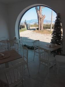 Regia Dimora في إبولي: غرفة بها طاولات وكراسي وشجرة عيد الميلاد