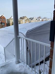 Cozy bedroom in family house 2 في لونغويل: سقف مغطى بالثلوج مع غطاء أبيض على شرفة