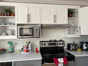 Cozy bedroom in family house 2 في لونغويل: مطبخ مع موقد وميكروويف