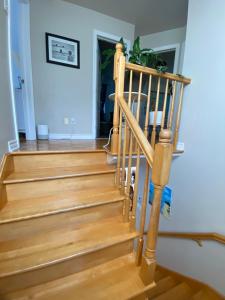 Cozy bedroom in family house 2 في لونغويل: درج في منزل مع أرضيات خشبية