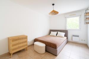 ein Schlafzimmer mit einem Bett, einer Kommode und einem Fenster in der Unterkunft Appartement avec balcon parking Alès centre in Alès