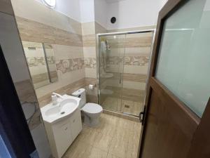 een badkamer met een toilet, een wastafel en een douche bij Regim parc in Craiova