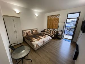 een slaapkamer met een bed, een tafel en een bank bij Regim parc in Craiova