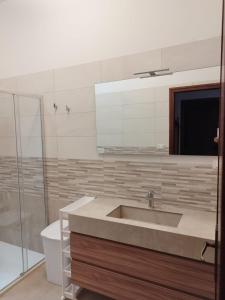 een badkamer met een wastafel en een douche bij Villetta Mirion in Marina San Gregorio