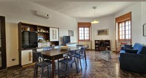 een woonkamer met een tafel, stoelen en een bank bij Villetta Mirion in Marina San Gregorio