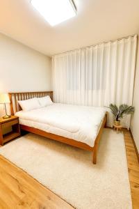 een slaapkamer met een groot bed en een raam bij new홍대 연남동 아늑한 감성숙소#최대4인#연트럴파크#짐보관#올리브영 in Seoul