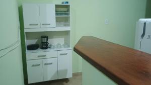 a kitchen with white cabinets and a wooden counter top at Apartamento para até 8 pessoas em Conservatória in Conservatória