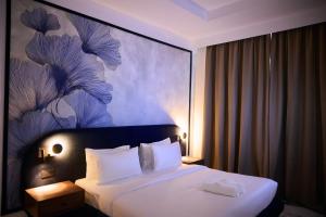 Un pat sau paturi într-o cameră la Azusa Hotel and Apartments