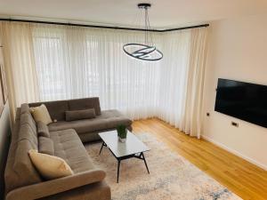 a living room with a couch and a tv at Dinka Apartments Park Lake in Tuzla
