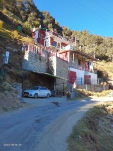 a car parked in front of a house on a hill at COMMANDER VILLa in Mukteswar +22 photos