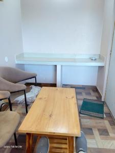 a table and chairs in a room with a desk at COMMANDER VILLa in Mukteswar