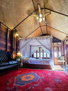 une chambre avec un lit avec un ventilateur de plafond dans l'établissement Camelliana Horizon Pongyang, à Mae Rim