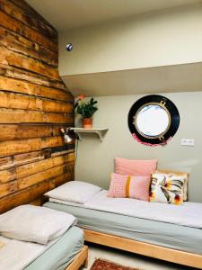 two beds in a room with a wooden wall at Houseboat Tante Piet in Amsterdam