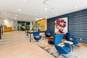a lobby with blue chairs and a painting on the wall at Metro Close - Relax Suite with Massage Chair and Parking in Arlington