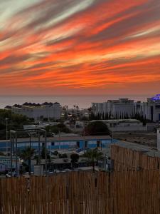 a sunset over a city with buildings and the ocean at Tamonda in Tamraght Ouzdar