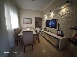 Casa de maria في بوا فيستا: غرفة طعام مع طاولة وتلفزيون على الحائط