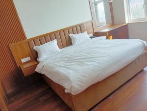 Sawarthia Sewa Sadan shahnewajpur manjha ayodhya في Jāmb: سرير بشرشف ووسائد بيضاء في الغرفة