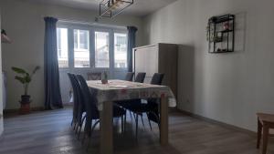a dining room with a table with chairs and a refrigerator at Jagersrust aan zee in Blankenberge