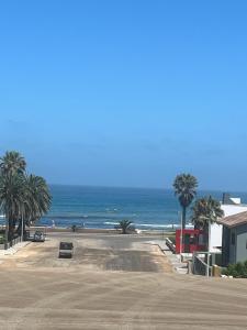 an empty parking lot next to a beach with palm trees at By the Sea in Swakopmund