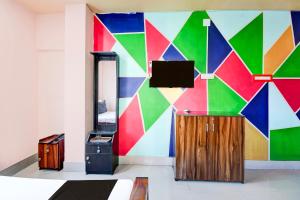 a room with a colorful wall with a tv at Hotel O Elixir in Dohāri