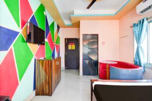 a room with a colorful wall with a table and a chair at Hotel O Elixir in Dohāri