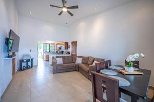 una sala de estar con un sofá y una mesa en Casa Alegria, en Jacó