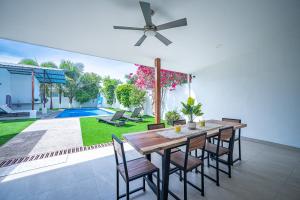 comedor con mesa, sillas y piscina en Casa Alegria, en Jacó
