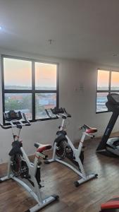 a gym with several exercise bikes in a room with windows at Alton City Loft in Jatingaleh